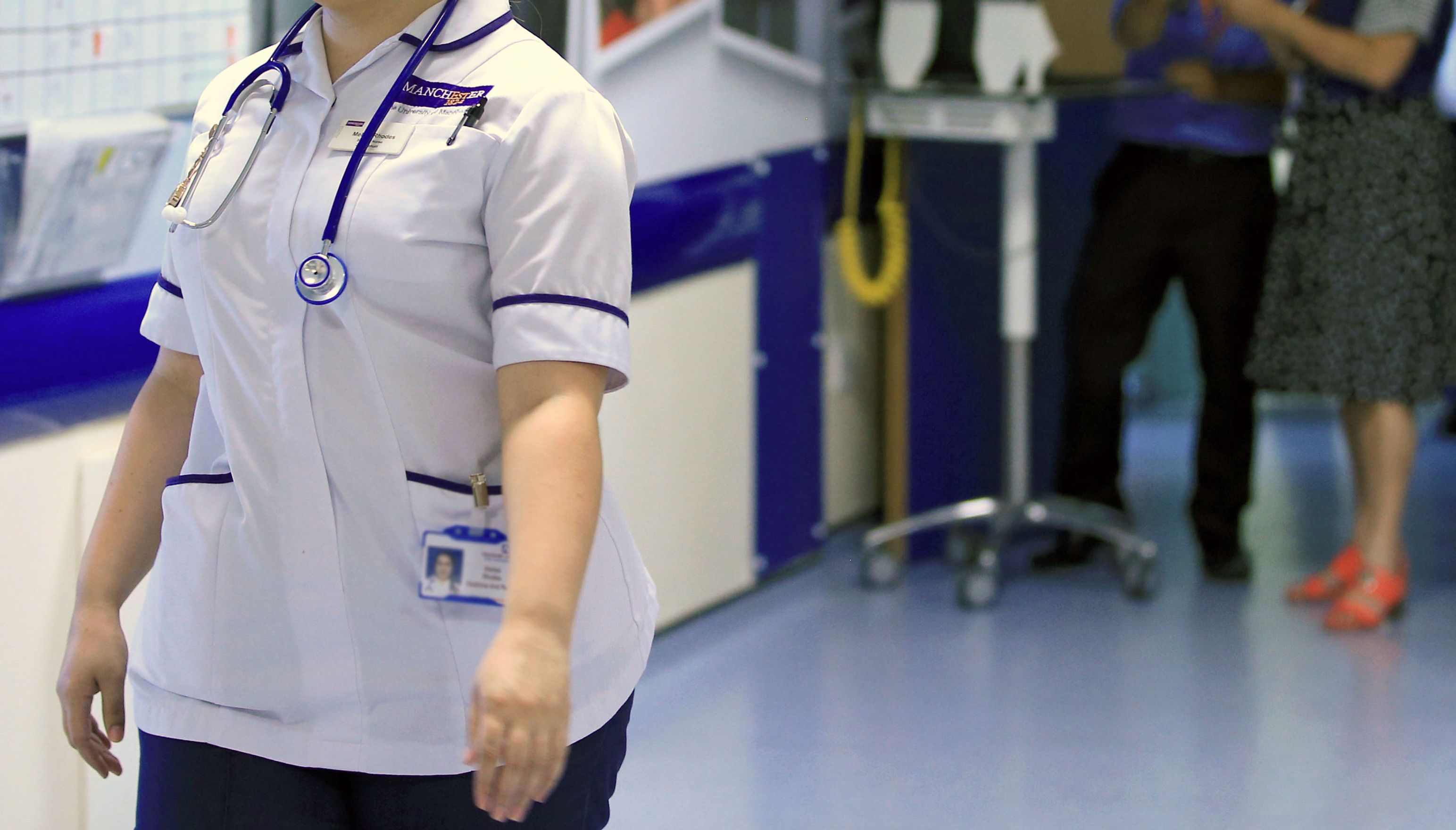 NHS worker walking through a hospital ward.