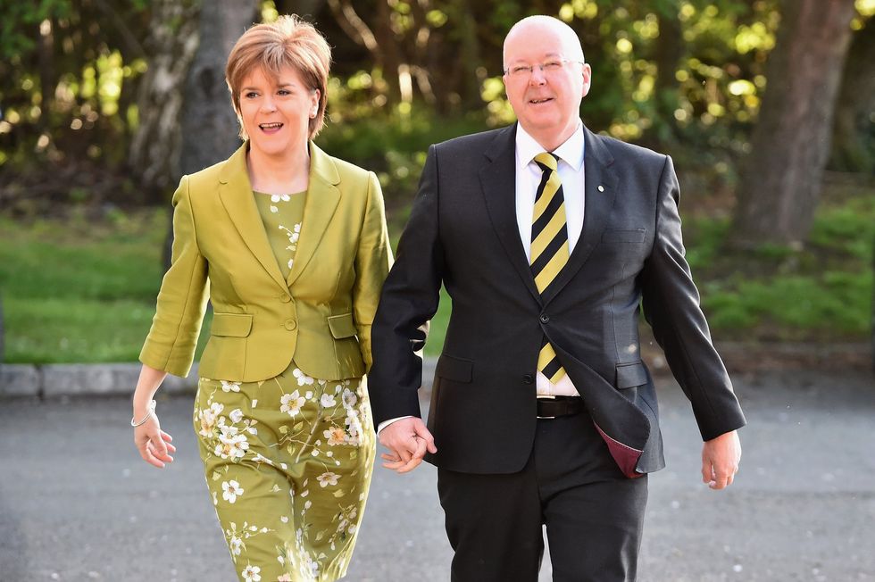 Nicola Sturgeon (left) and Peter Murrell (right) holding hands