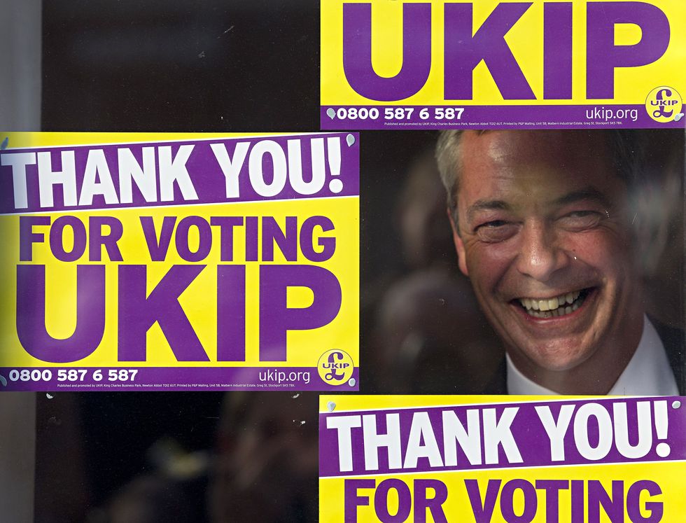 Nigel Farage is pictured as he looks through a window of the UKIP office in Clacton-on-Sea