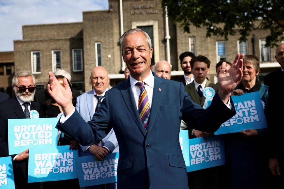 Nigel Farage reacts next to newly elected councillors at the Havering Town Hall,