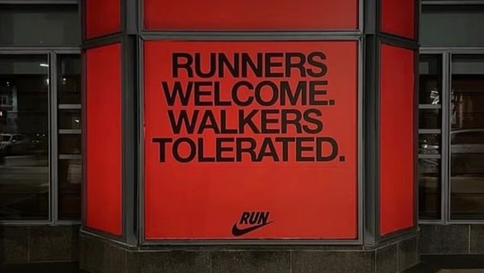 Nike has been compelled to remove a controversial sign from its Boston store following fierce criticism from marathon participants ahead of today's race