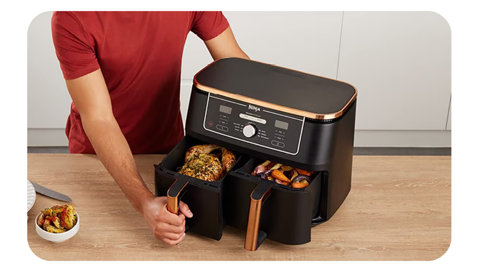 ninja foodi max pictured with both drawers open, one filled with a whole chicken and the other with cooked vegetables