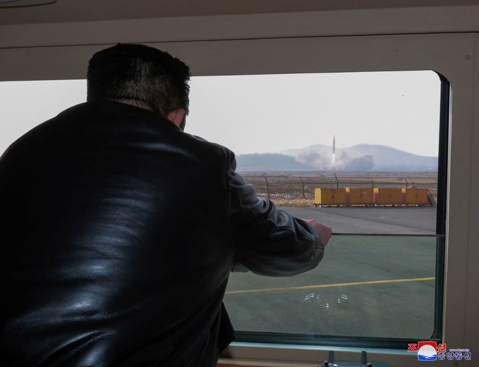 North Korean leader Kim Jong-un looks through a window during the test firing of what state media report is a \%22new type\%22 of intercontinental ballistic missile (ICBM) in this undated photo released on March 24, 2022.
