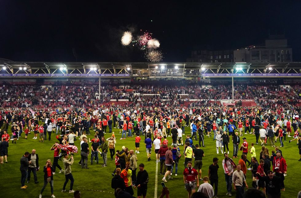 Nottingham Forest fans celebrate on the pitch after they reach the play off final during the Sky Bet Championship play-off semi-final, second leg match at the City Ground, Nottingham. Picture date: Tuesday May 17, 2022.