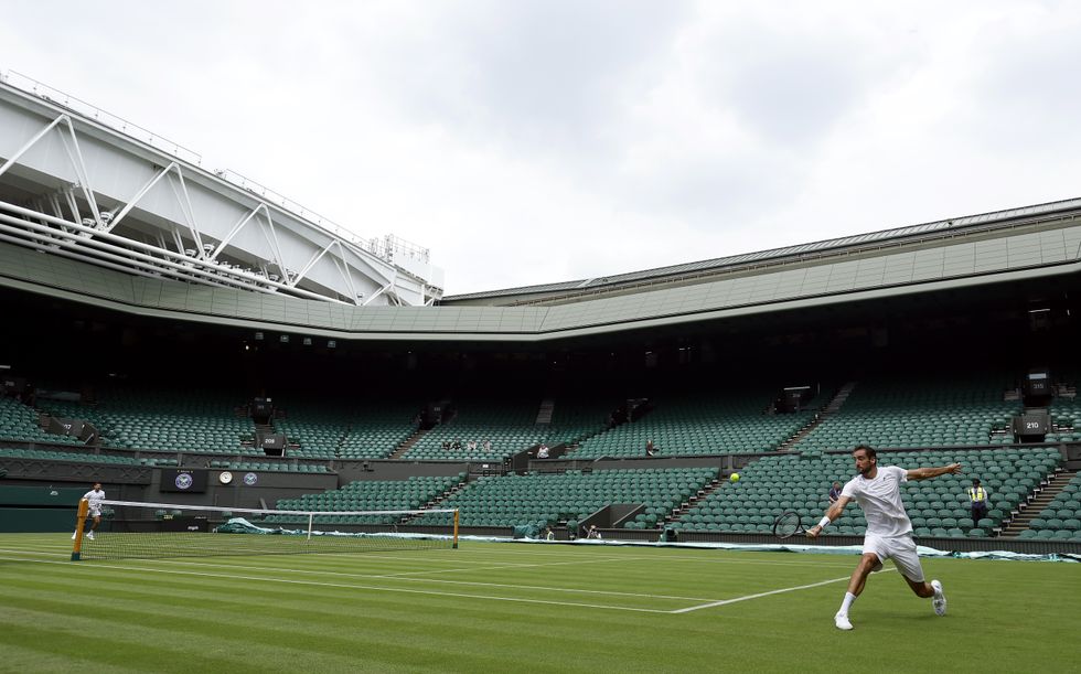 Novak Djokovic (left) and Marin Cilic practice on centre court ahead of the 2022 Wimbledon Championship at the All England Lawn Tennis and Croquet Club, Wimbledon. Picture date: Thursday June 23, 2022.