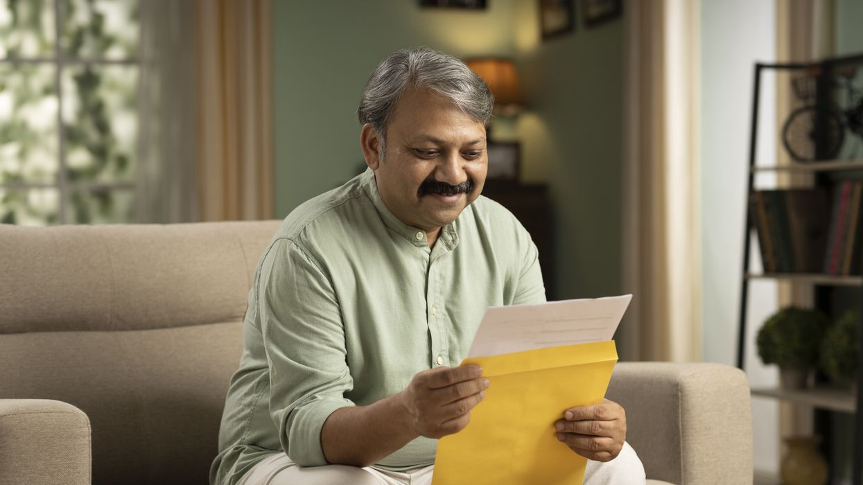 NS&I logo and person looks at envelope happily