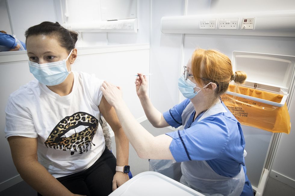 Nurse Eleanor Pinkerton administers a coronavirus vaccine to one of the health and social care staff at the NHS Louisa Jordan Hospital in Glasgow.