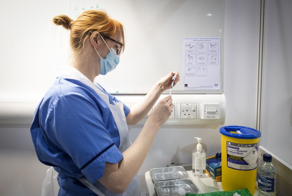 Nurse Eleanor Pinkerton prepares a coronavirus vaccine to be given to a health and care staff member at the NHS Louisa Jordan Hospital in Glasgow, as part of a mass vaccination drive by NHS Greater Glasgow and Clyde. Picture date: Saturday January 23, 2021.