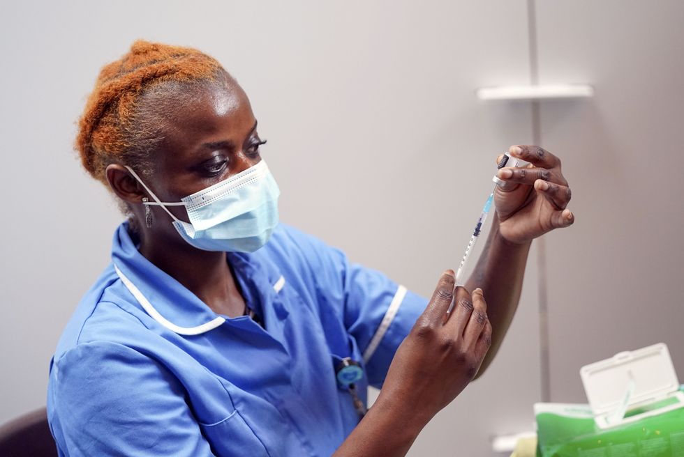 Nurse Marvis Birungi prepares to give a vaccine injection.