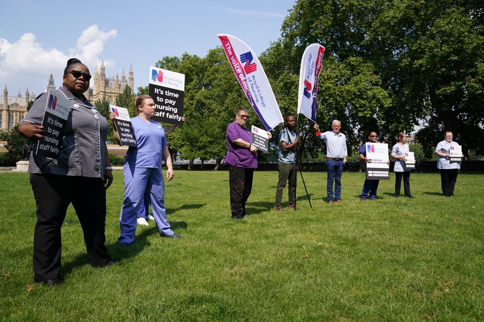 Nurses with placards outside the Royal College of Nursing (RCN) in Victoria Tower Gardens, London.