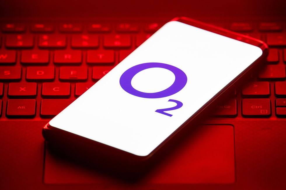 o2 logo pictured on a smartphone that's laying on a laptop keyboard