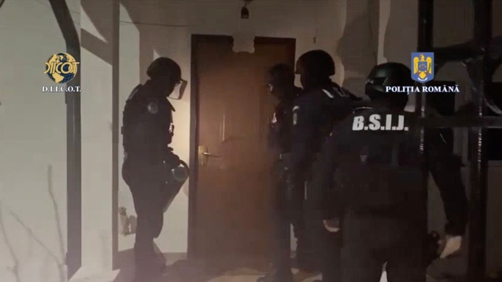 Officers attempt to open a door during the raid of Tate's property