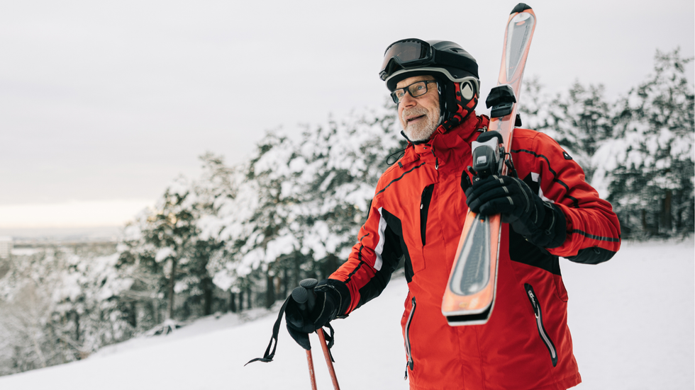 Old man carrying skis