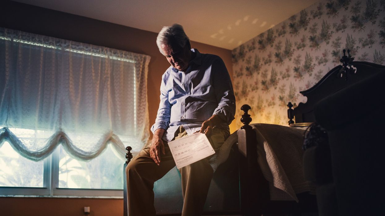 Older man holding bill
