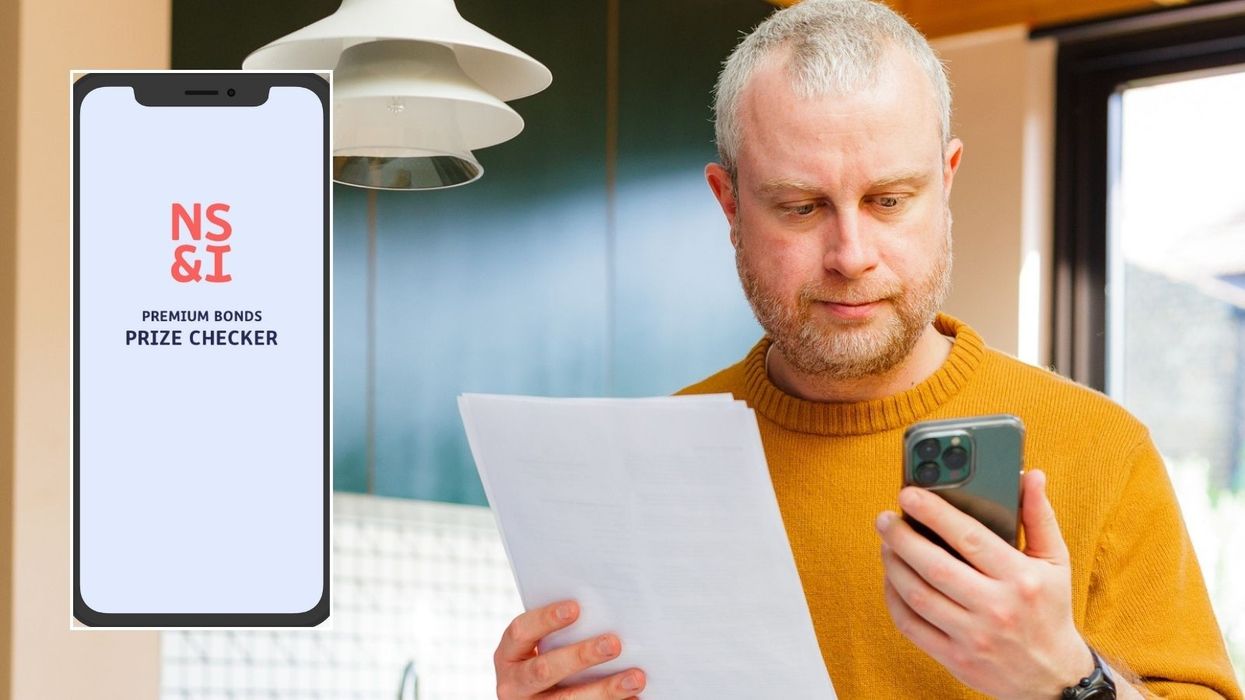 Older man looking at phone and NS&I prize checker