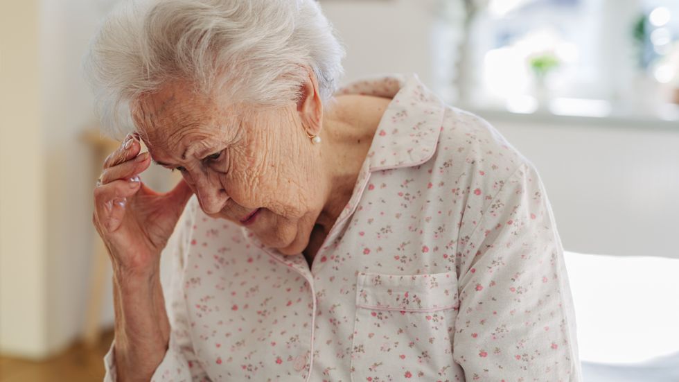 Older woman holding her hand to her head