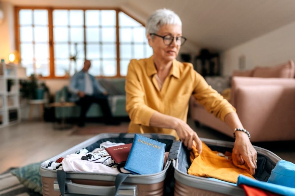 Older woman packing suitcase