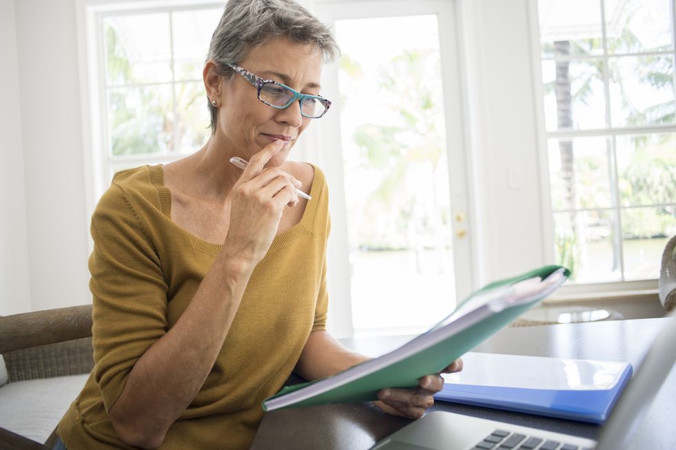 Older woman reading folder for information