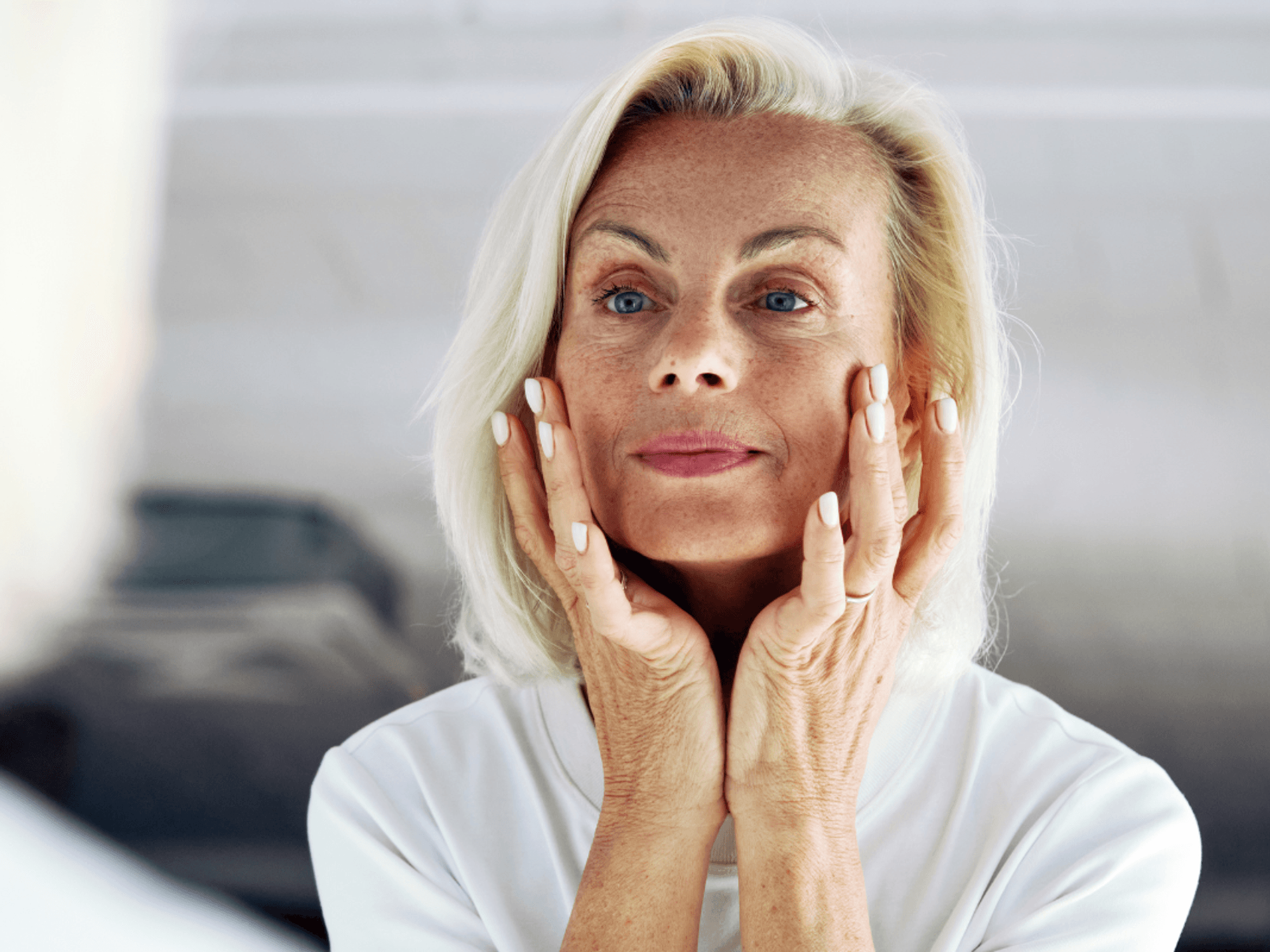 Older woman touching face