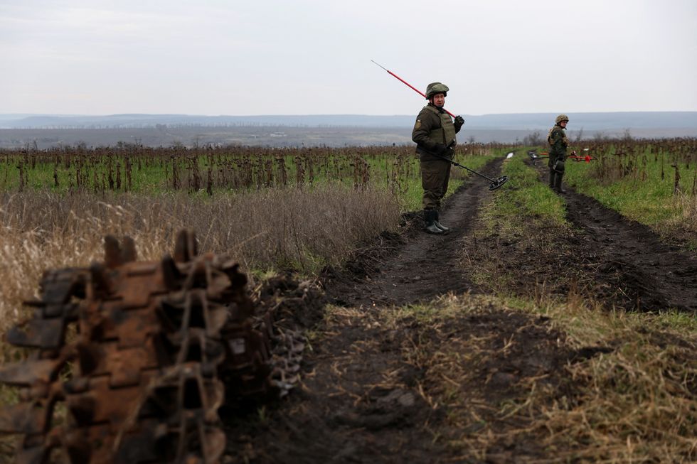 Olexandr, 41, and Petro, 50, members of the Ukrainian National guard demining team Battalion Dnipro 1, walk in mine fields, as Russia\u2019s attack on Ukraine continues, in the northern part of the Donetsk region of Ukraine, December 12, 2022. REUTERS/Shannon Stapleton