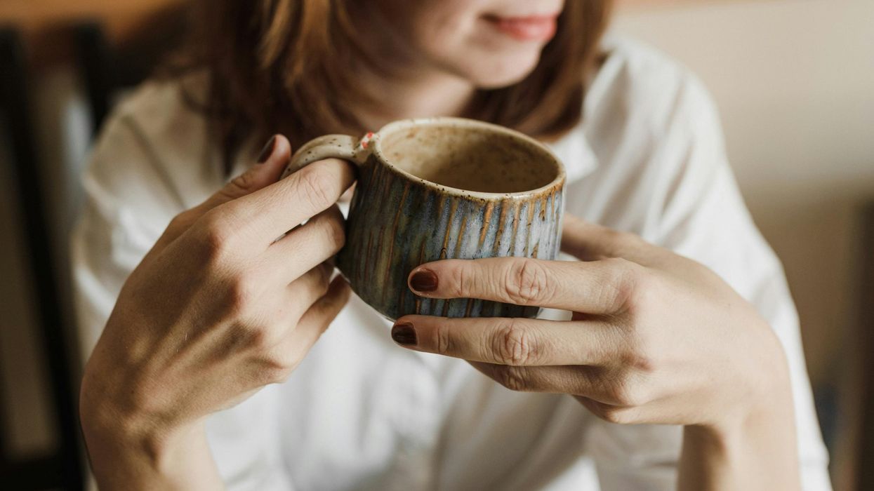 oman holding cup of coffee