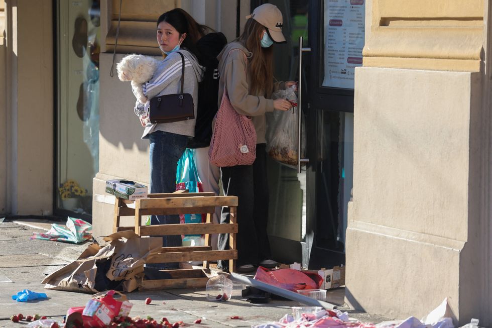 Onlookers observe the scene and debris left from the incident