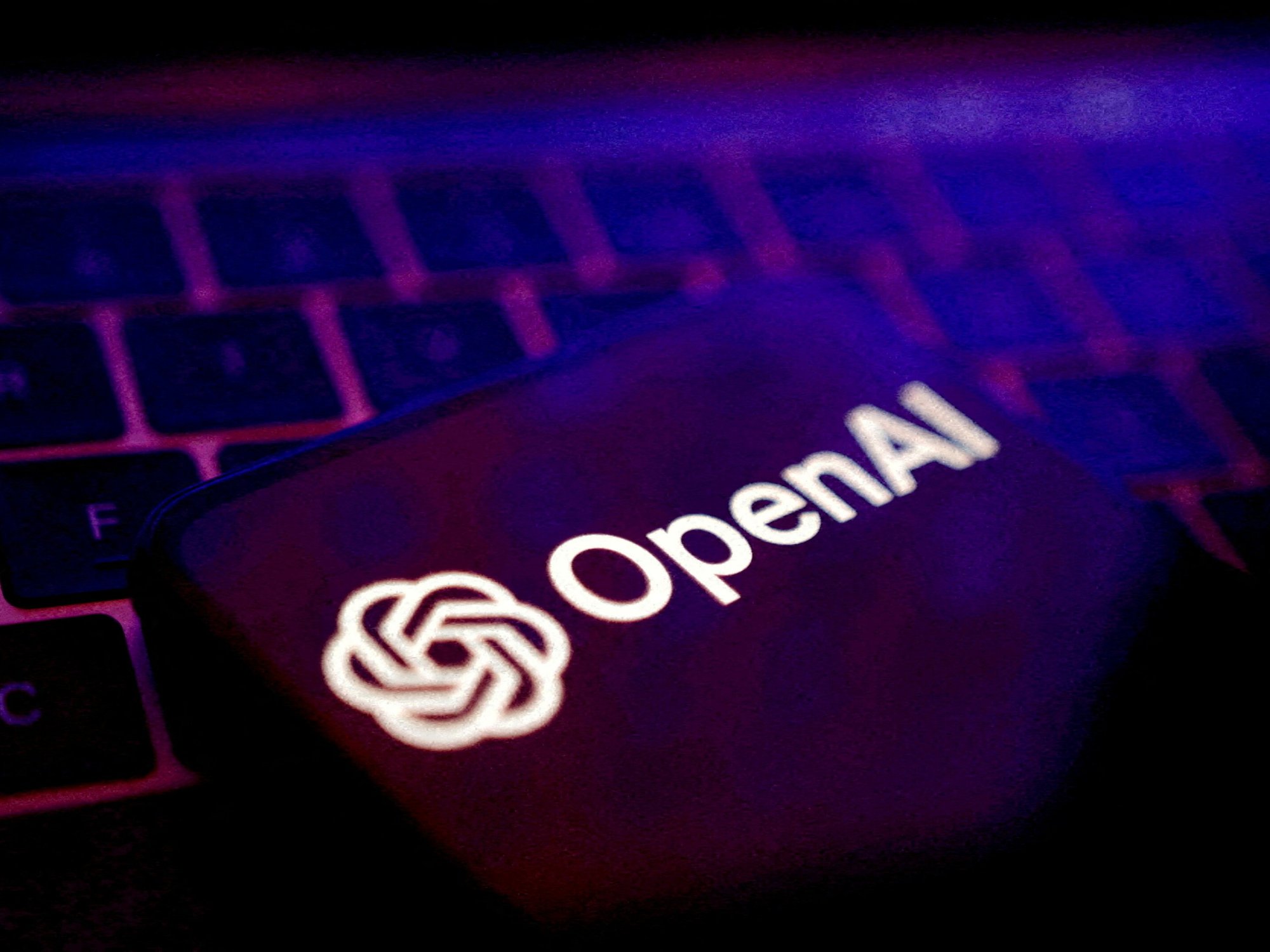 openAI logo pictured on a smartphone resting on a keyboard