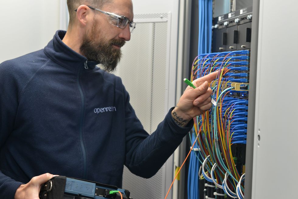 Openreach engineer checks the broadband cables in a cabinet