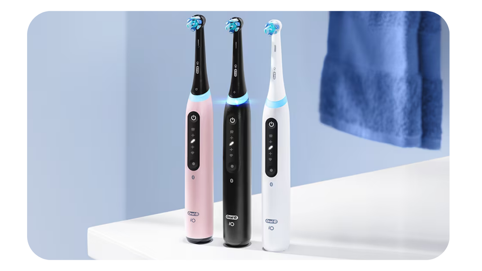 oral b toothbrush lined up on the bathroom cabinet in three colour options