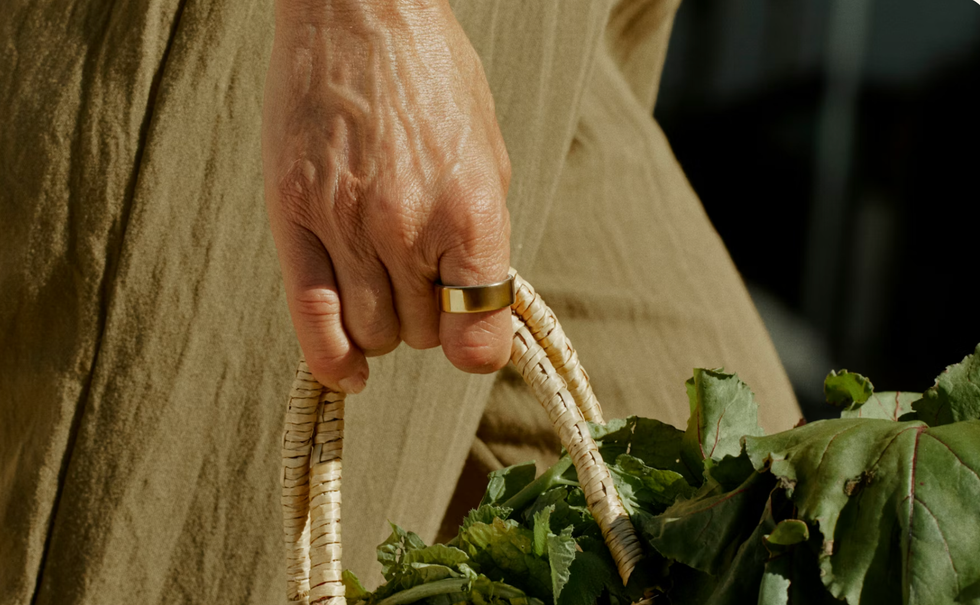 Oura Ring 4 in gold metallic worn on hand