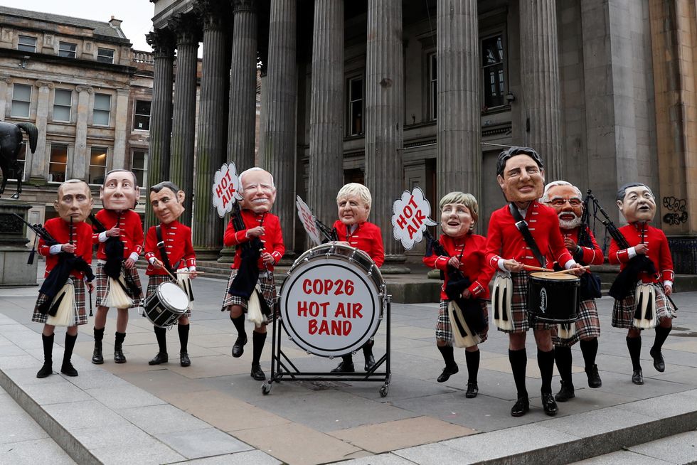 Oxfam activists with 'Big Heads' of Russia's President Vladimir Putin, Italy's Prime Minister Mario Draghi, France's President Emmanuel Macron, U.S. President Joe Biden, Britain's Prime Minister Boris Johnson, Germany's Chancellor Angela Merkel, Canada's Prime Minister Justin Trudeau, India's Prime Minister Narendra Modi and China's President Xi Jinping perform in a Scottish pipe band, as the UN Climate Change Conference (COP26) takes place in Glasgow, Scotland, Britain, November 1, 2021. REUTERS/Lee Smith