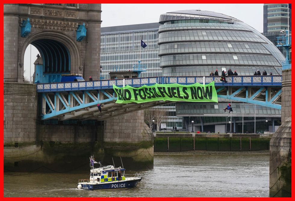 PABest Activists from Extinction Rebellion hang from suspension cords beside a giant banner that reads %22End fossil fuels now%22, as they stage a protest on Tower Bridge, east London, which has been closed to traffic. Picture date: Friday April 8, 2022.
