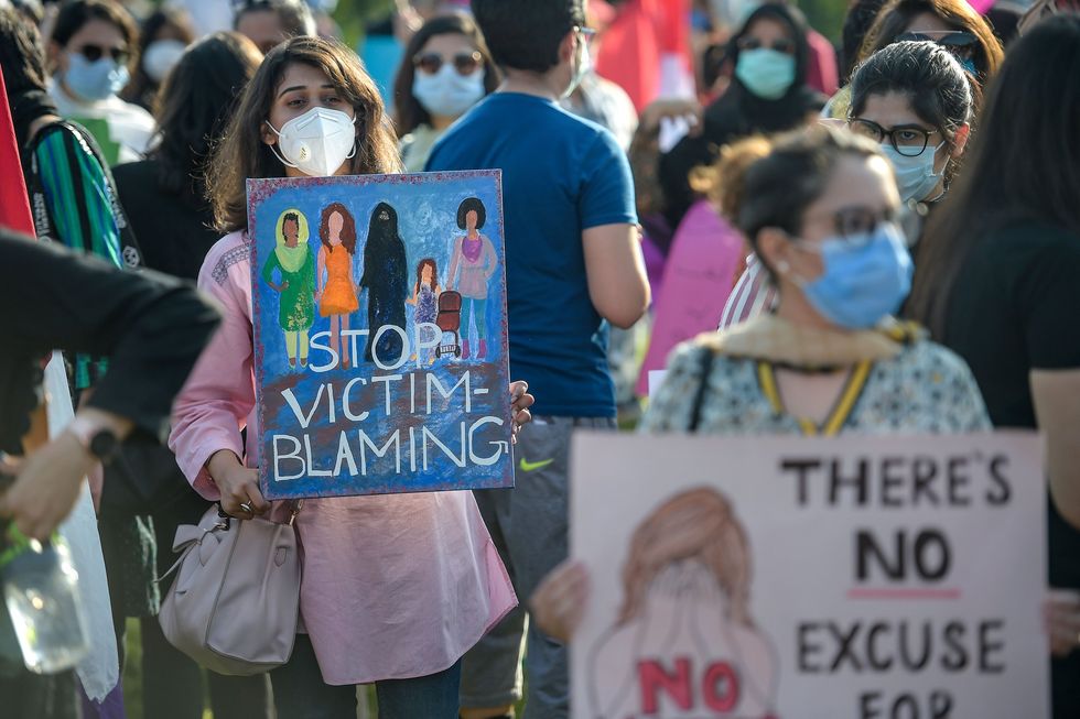 Pakistani protester holding a sign which read 'stop victim-blaming'