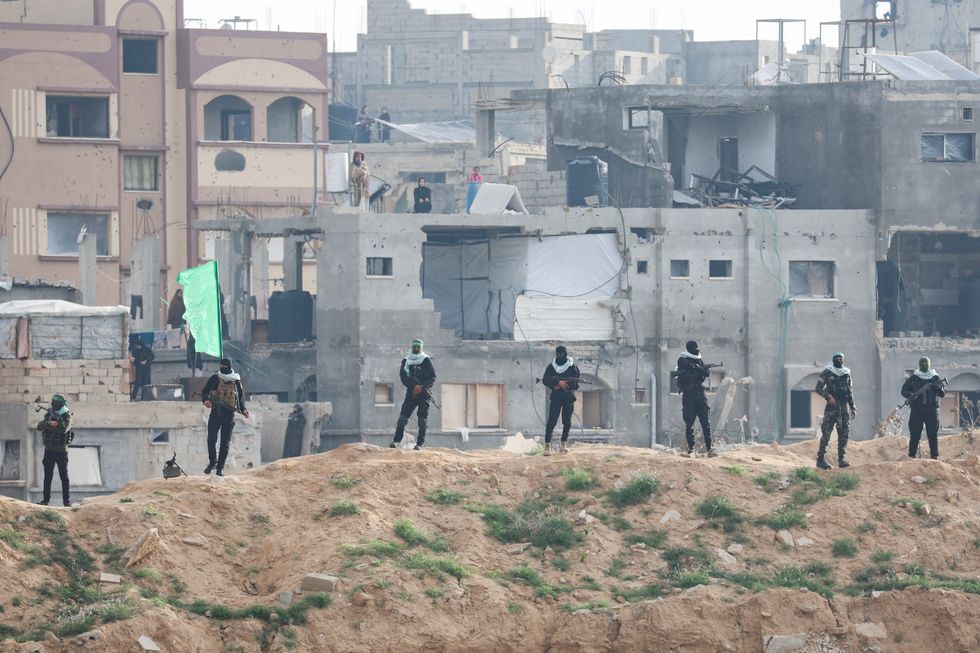 Palestinian Hamas militants keep guard on the day Hamas hands over deceased hostages \u200b
