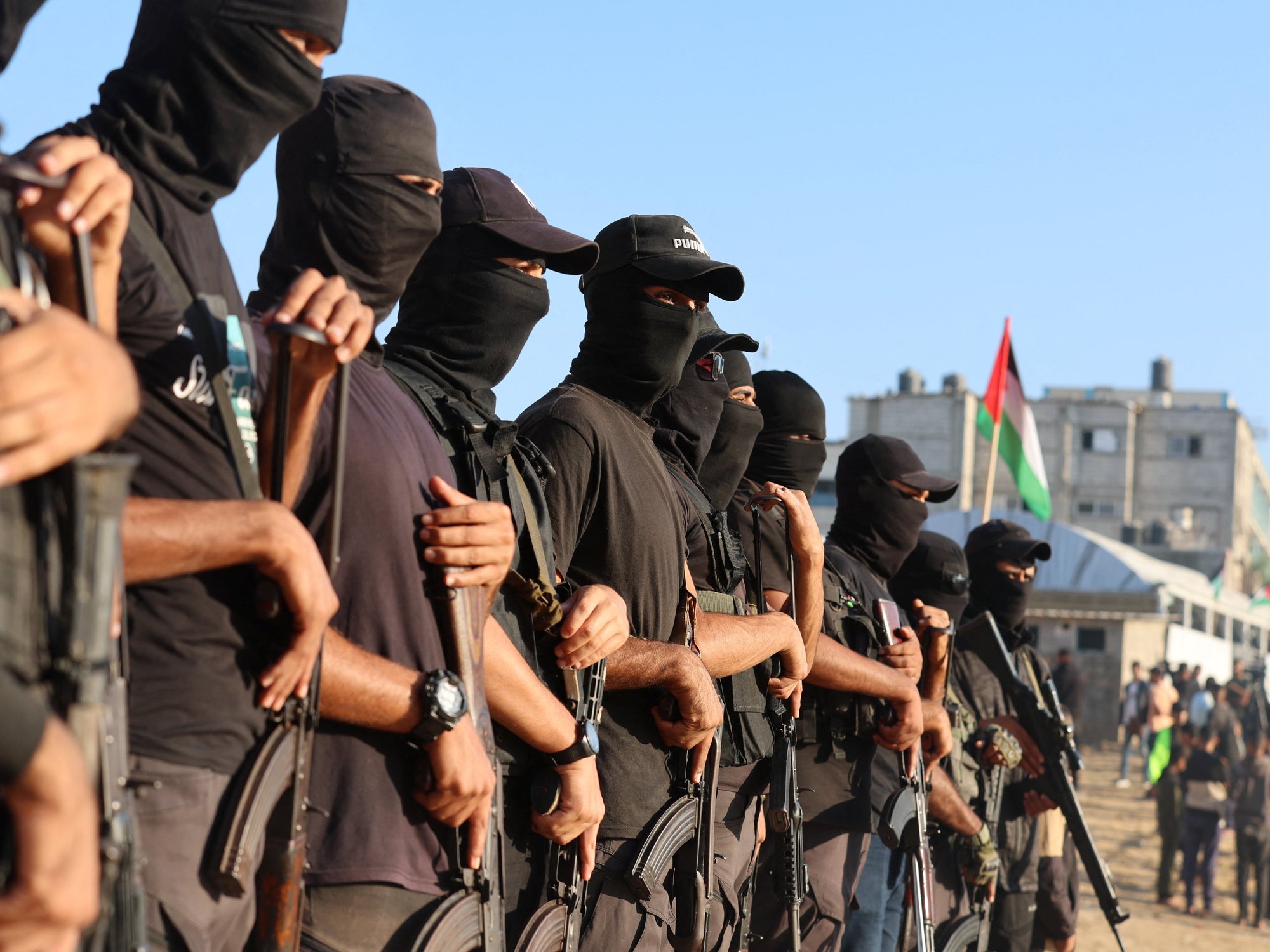 Palestinian militants stand guard on the day that hostages held in Gaza since the deadly October 7 attack are handed over