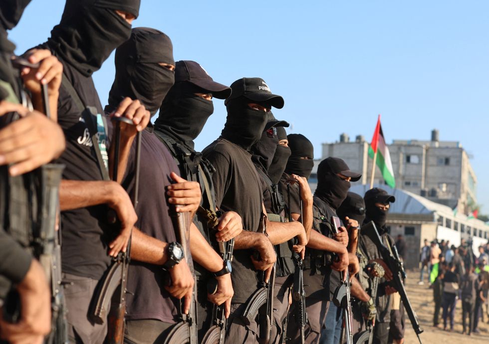Palestinian militants stand guard on the day that hostages held in Gaza since the deadly October 7 attack are handed over