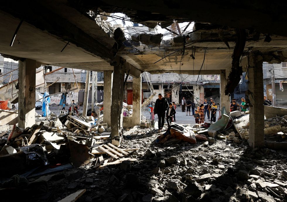 Palestinians inspect the site of an Israeli strike on a house