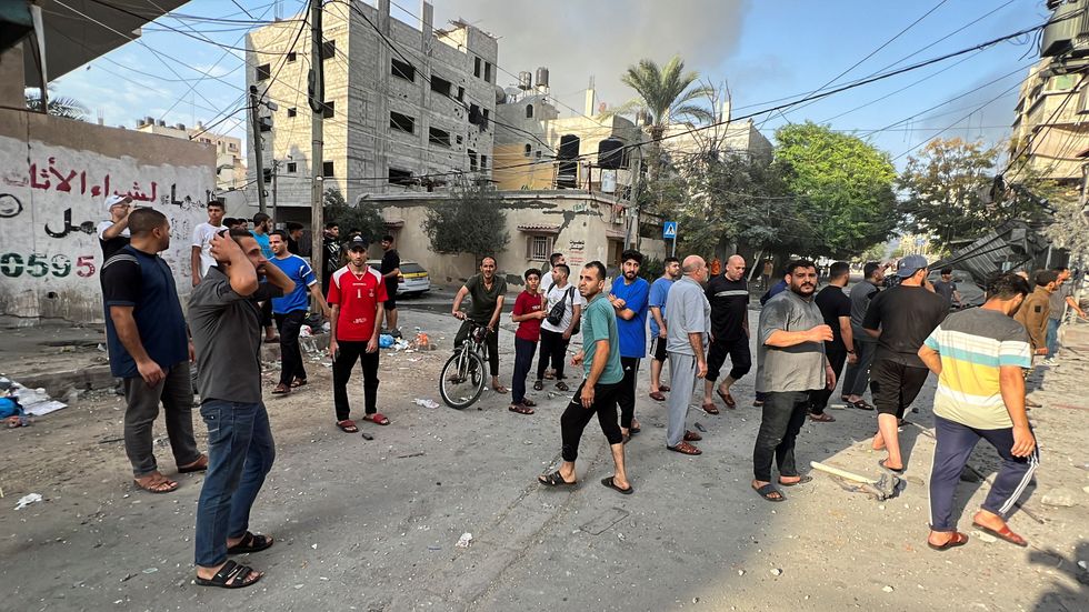 Palestinians search for casualties at the site of Israeli strikes on houses, in Gaza City