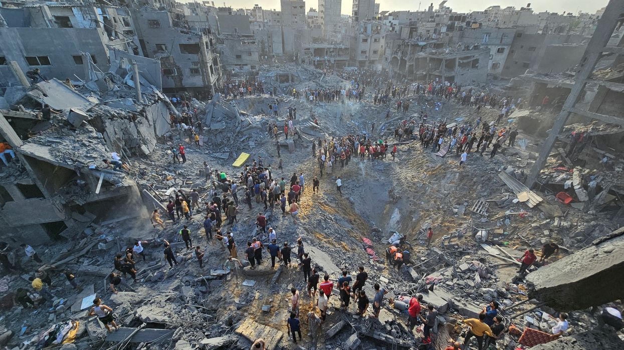 Palestinians search for casualties at the site of Israeli strikes on houses in Jabalia refugee camp in the northern Gaza Strip