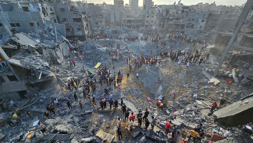 Palestinians search for casualties at the site of Israeli strikes on houses in Jabalia refugee camp in the northern Gaza Strip