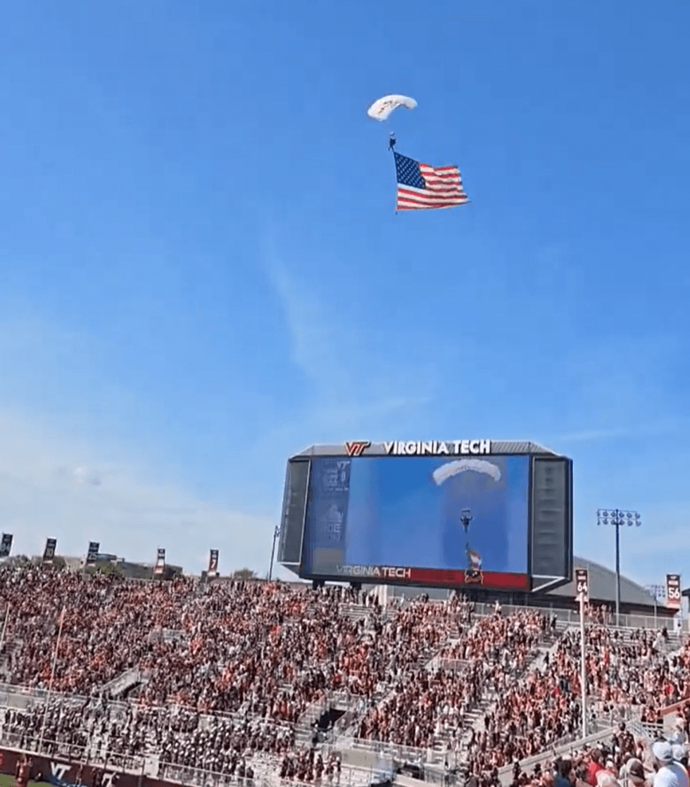 Parachuter seen descending down holding American flag