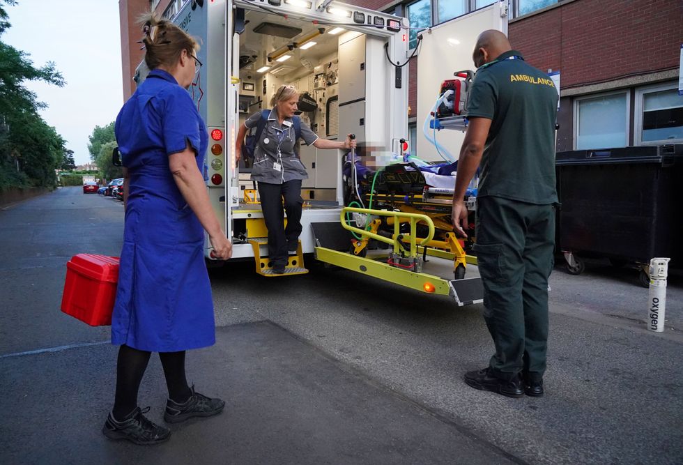 Paramedics arrive at St. George's Hospital along with their young patient who is set down from an ambulance operated by paramedics from the South Thames Retrieval Service (STRS)