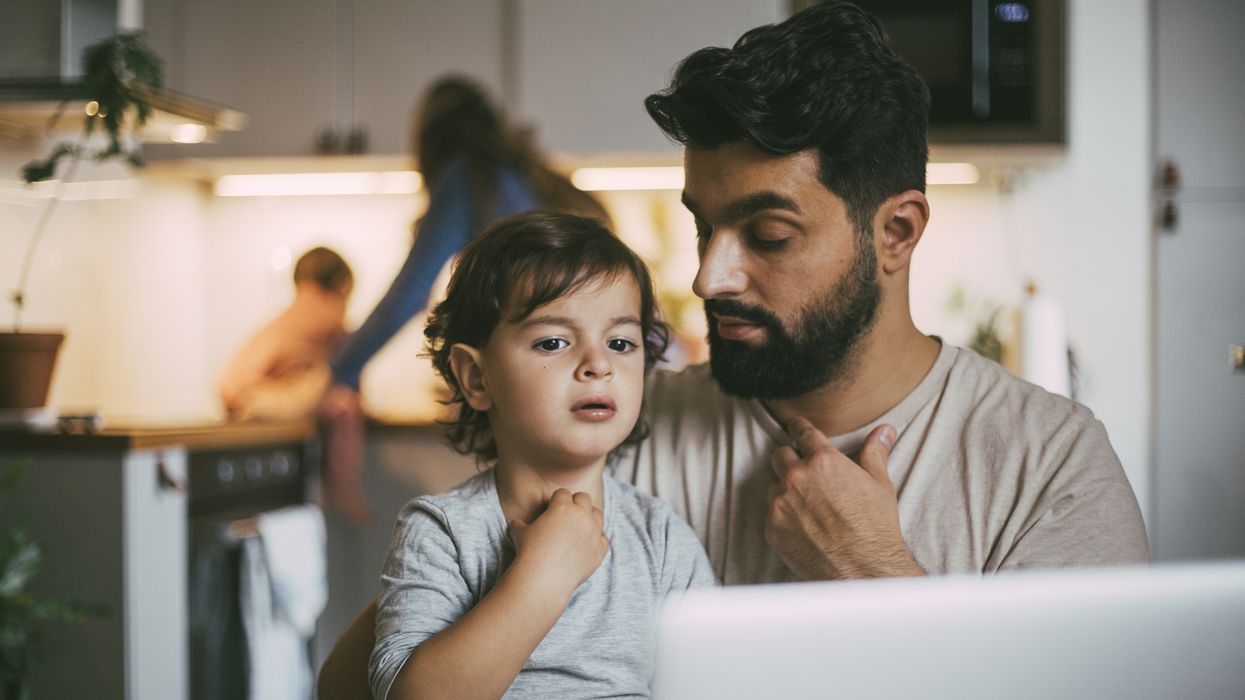 Parent and child look at laptop while deciding whether to buy Premium Bonds