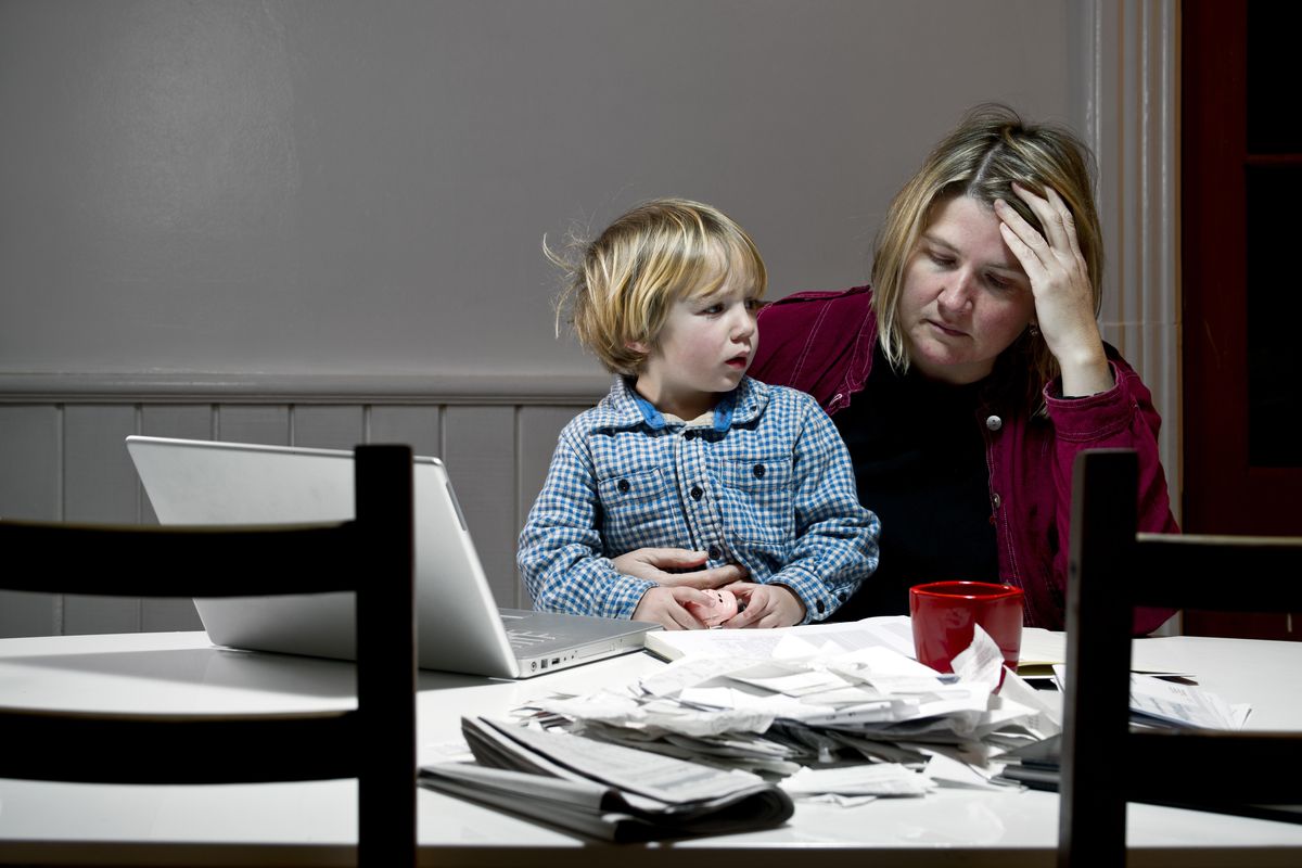 Parent and child sit together while looking at finances