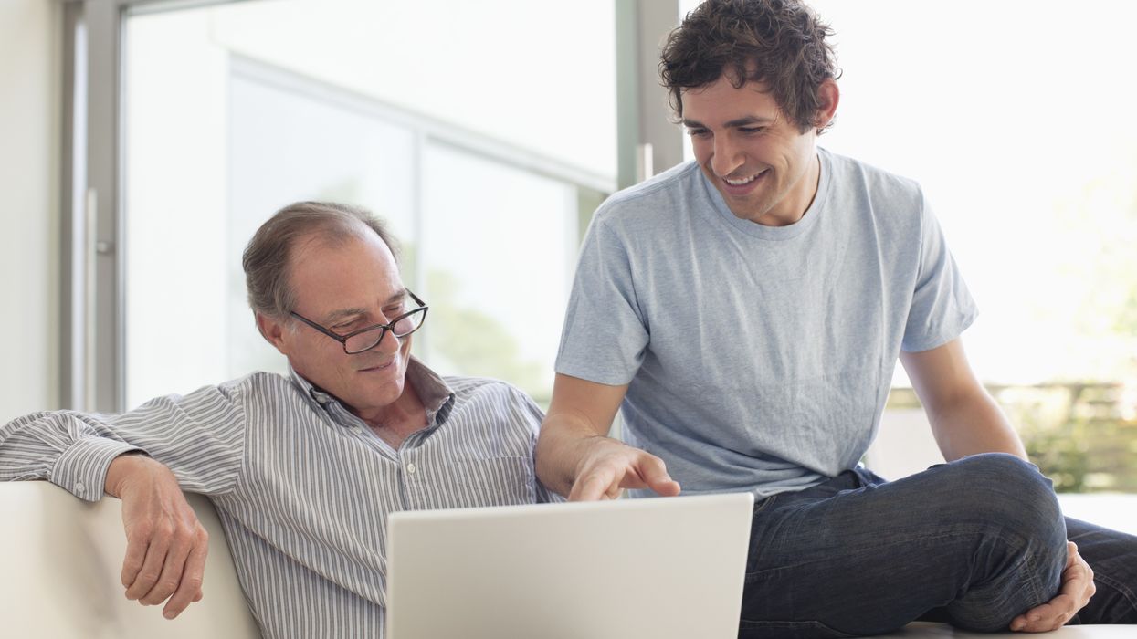 Parent and son look at laptop
