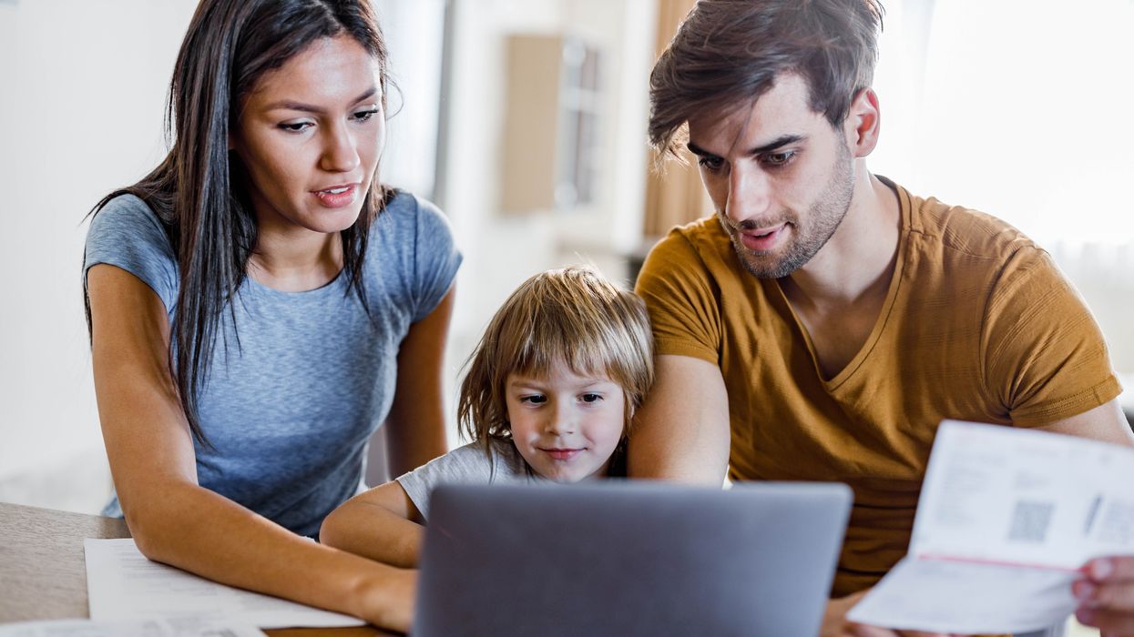 Parents and child look at laptop and statement
