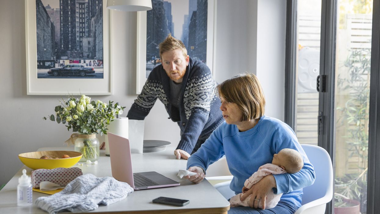 Parents look at laptop with child beside them
