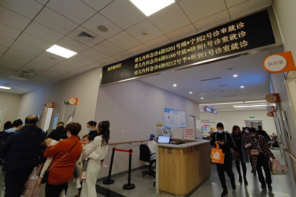 Parents take their children to see a doctor at the pediatric emergency department of a hospital in Shanghai