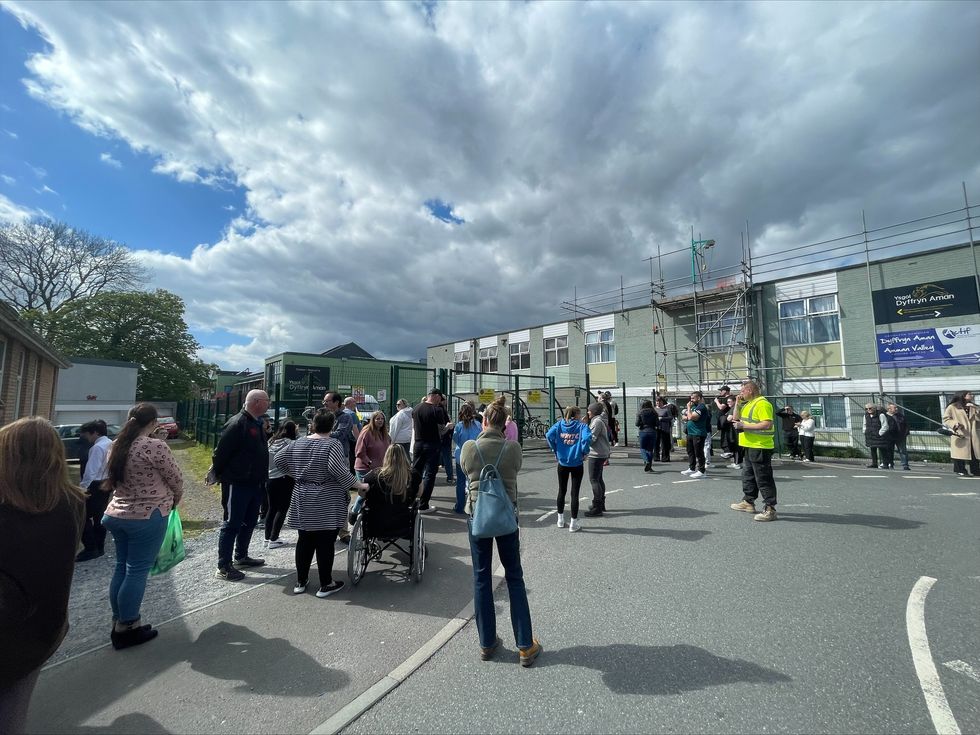 Parents wait at the gates of Amman Valley school, in Ammanford, Carmarthenshire