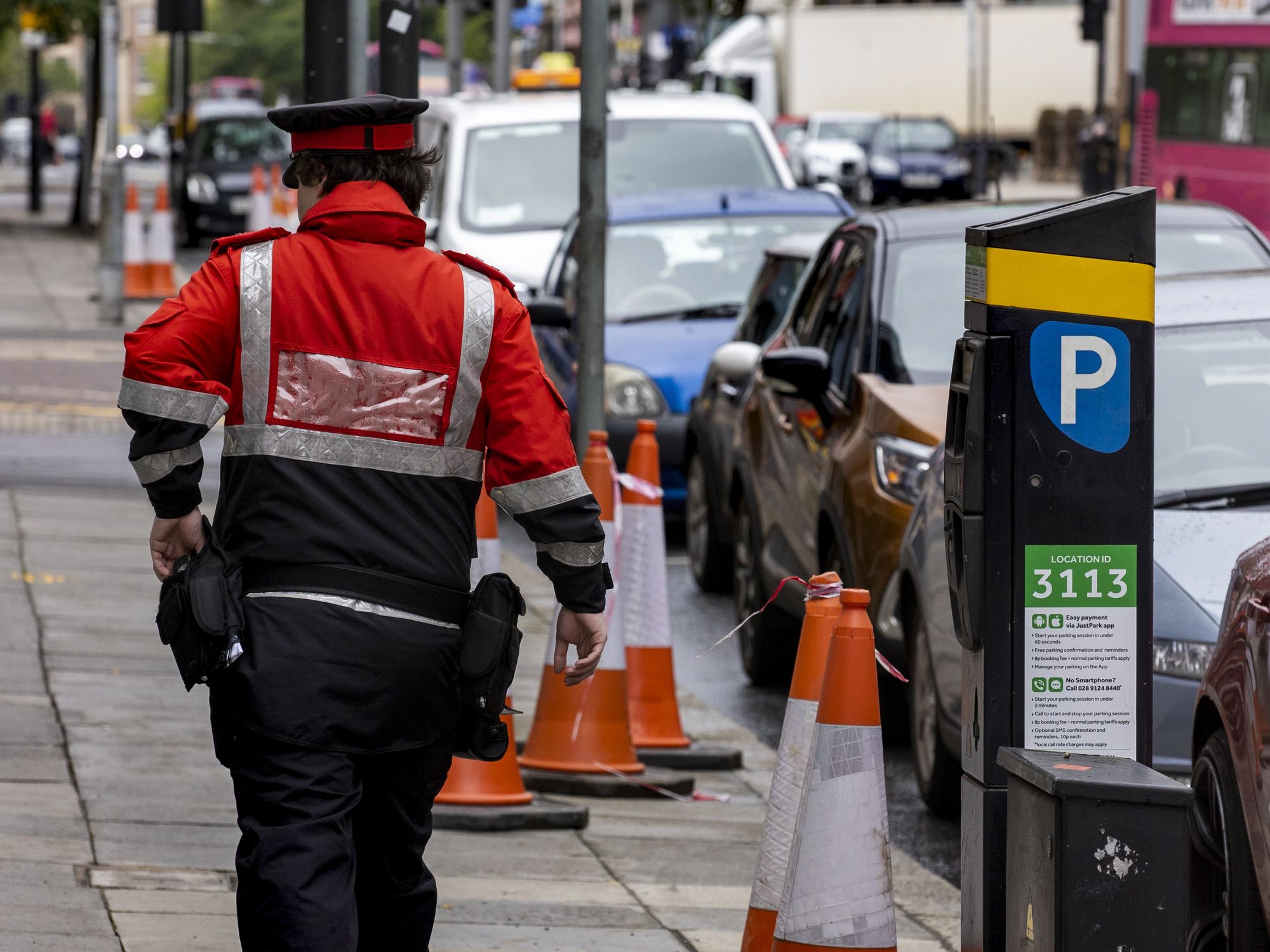 Parking inspector walking past a pay and display